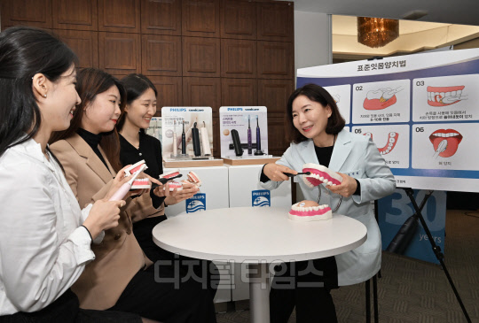 조민정(오른쪽 첫번째) 대한구강보건협회 이사가 구강 모형을 이용해 참석자들에게 표준잇몸양치법을 알리고 있다. <사진제공=필립스코리아>